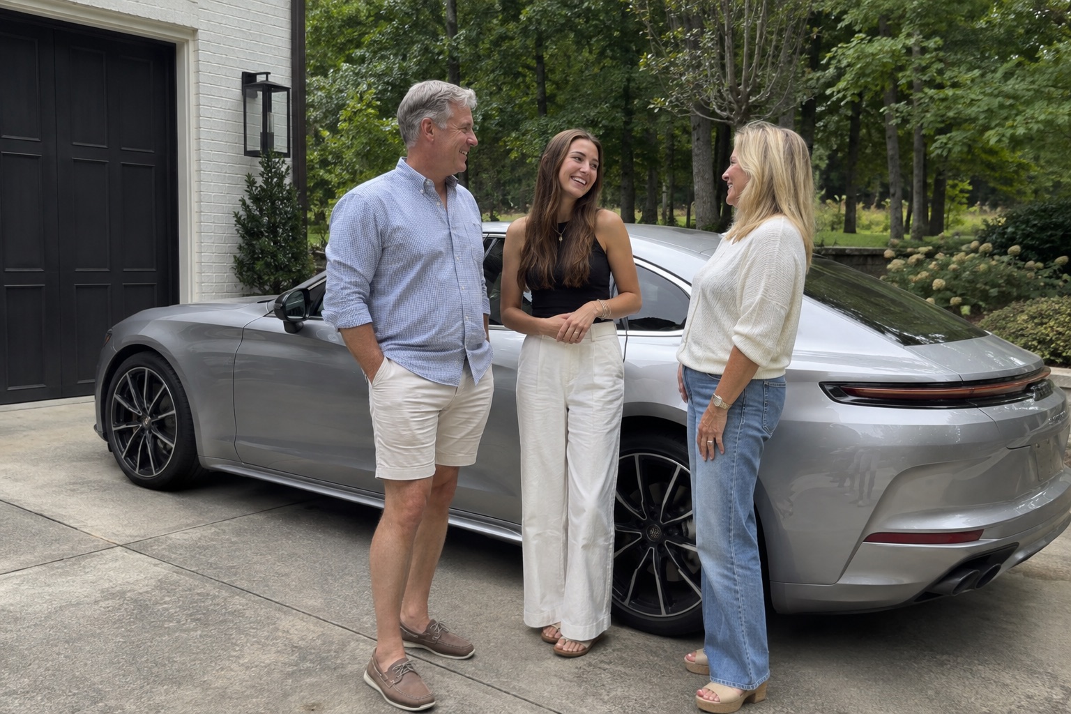 Illustrative candid scene of three adults beside a luxury sedan