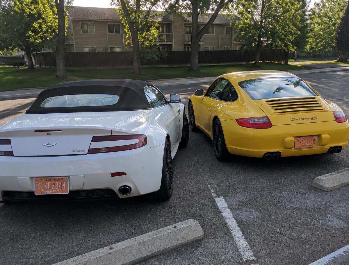 White convertible and yellow Porsche with Montana plates in a parking lot